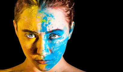 Woman covered with yellow and blue paints