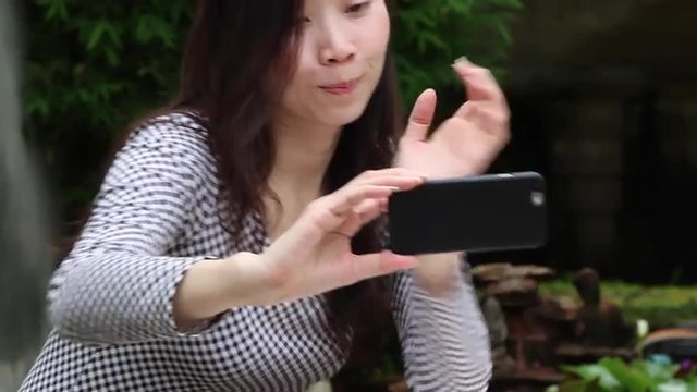 Asian woman take a selfie photo in the garden