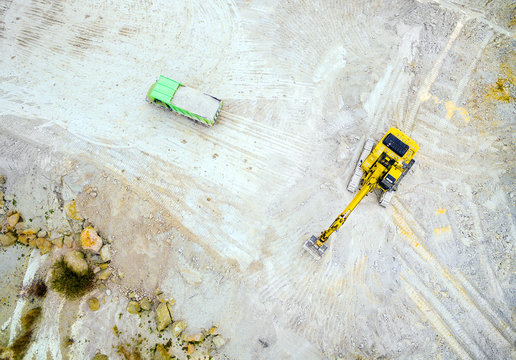 Aerial view of a excavator and truck in the opencast mine. Industrial background from landscape after mining. 