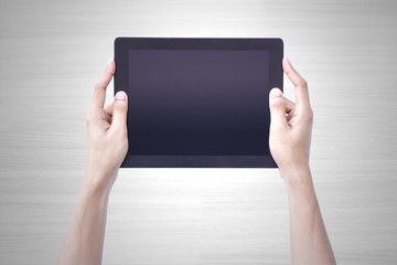 Man hand holding tablet tablet screen showing up overhead person wood background concept for...