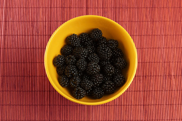 Fresh blackberries in a yellow bowl
