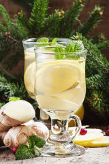 Obraz na płótnie Canvas Hot ginger lemon tea in Christmas decoration with fir branches a