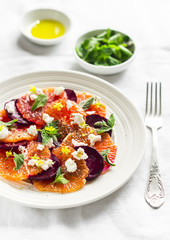 salad with beets, oranges and soft cheese on a white plate