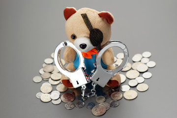 handcuff teddy bear with coins. crime concept