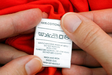 Woman hands holding clothes label