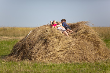 Naklejka na ściany i meble Children resting in the hay
