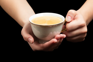 cup of coffee in hands of a woman isolated on black