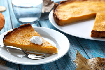 Tasty pumpkin pie on plate on a blue wooden table