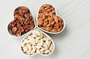 Assorted nuts in bowl on wooden table