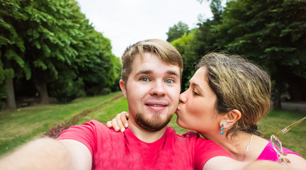  young couple taking  selfie in a park