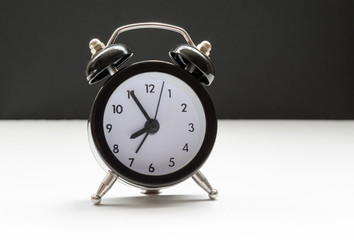 Time passing concept. Black and white with alarm clock on the nightstand