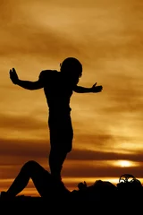 Foto op Plexiglas silhouette of a football player after a tackle © Poulsons Photography