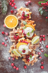 Fototapeta na wymiar Waffles with cranberries served with orange ice cream. Festive decoration.