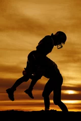 Foto op Plexiglas silhouette of a football player making a hard tackle © Poulsons Photography