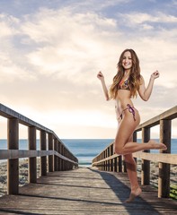 young pretty woman wearing bikini near the coast