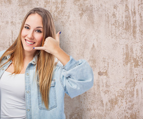 portrait of a pretty young woman making the gesture to call by telephone