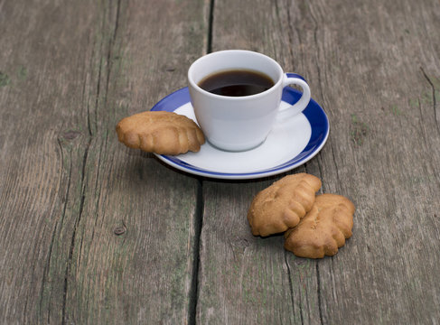 cup of coffee and some cookies on a wooden table