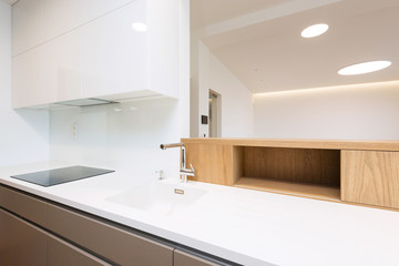 Fototapeta na wymiar Sink with tap on white worktop of contemporary kitchen