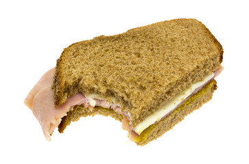 Bitten ham and cheese sandwich on a white background