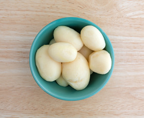 White potatoes in a bowl on wood table top