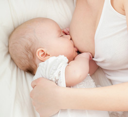 Young mother breastfeeds her baby. Breast-feeding.