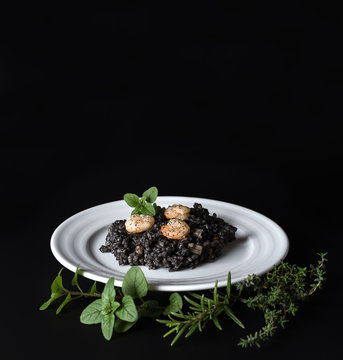 Black risotto and herbs