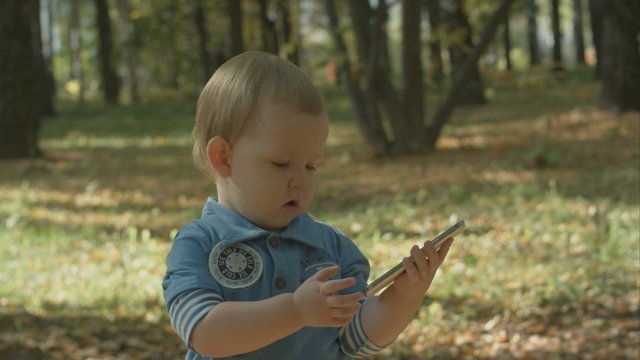 Adorable baby stops calling with cell phone.