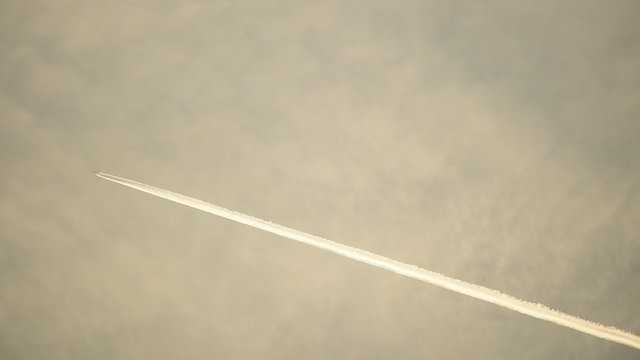 Airplane condensation trails on the sky at sunset