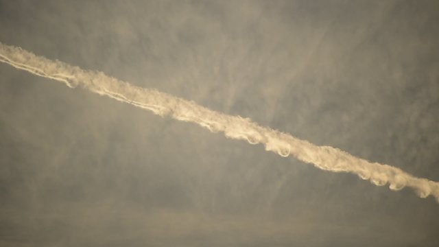 Airplane condensation trails on the sky at sunset