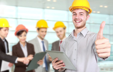Young businessman wear a safety helmet showing thumb up