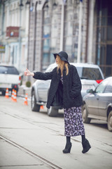 Fototapeta premium Fashionable young woman posing outside in a city street. Winter Fashion