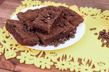On a wooden table on yellow  plate of chocolate truffle cake