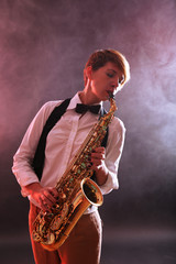 Fototapeta na wymiar Talent woman professionally plays saxophone in red smoke