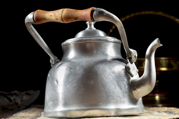 Old metallic kettle with wooden handle