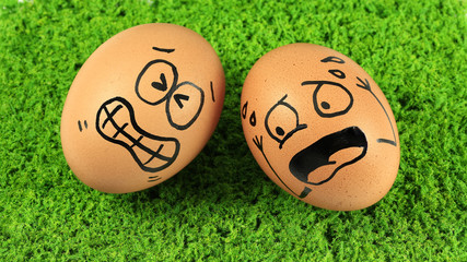Eggs with funny faces, funny action isolated on green grass back