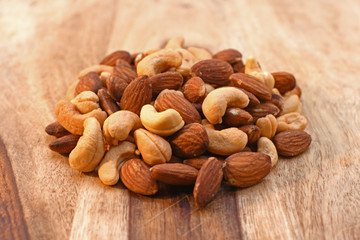 Salted mixed almond and cashew nuts on cutting board 