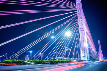 Fototapeta na wymiar long exposure car light tracks with bridge background