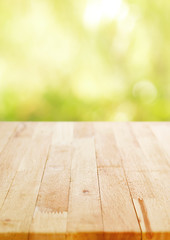 Wood table top on blur green bokeh background, poster size proportion