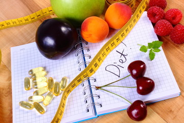 Fruits, tablets supplements and centimeter with notebook, slimming and healthy food
