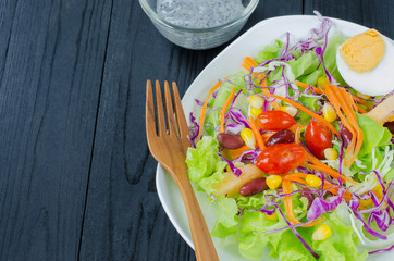 Fresh vegetable salad in dish on wooden selective fofus
