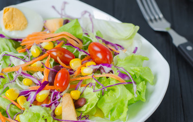 Fresh vegetable salad in dish on wooden selective fofus