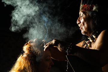A Mayan shaman performs an ayahuasca ceremony in the Amazon jungle of Ecuador, using plant medicine to heal and guide people in a spiritual ritual.