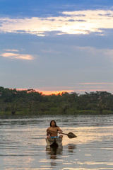 Explore the serene beauty of Laguna Grande Cuyabeno National Park Ecuador through this captivating image of an indigenous adult man with his canoe at sunset
