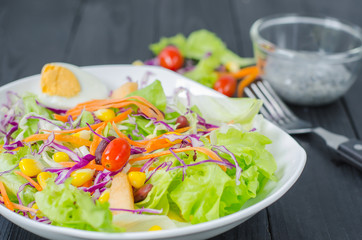 Fresh vegetable salad in dish on wooden selective fofus