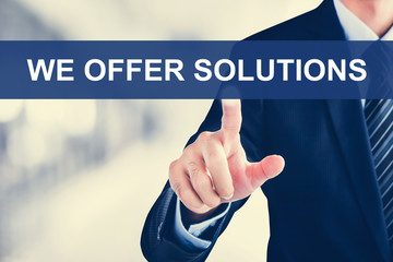 Businessman hand touching WE OFFER SOLUTIONS message on virtual screen