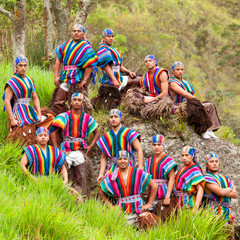 A picturesque outdoor shot capturing the vibrancy of an Ecuadorian folkloric group adorned in...