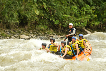 Thrilling white water rafting in Ecuador's rapids, as adventurous people navigate the rushing river amidst breathtaking water splashes.