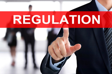Businessman hand touching  REGULATION sign on virtual screen