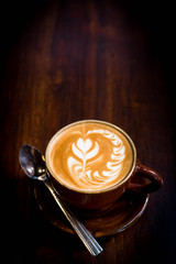 Hot art Latte Coffee in a cup on wooden table and Coffee shop bl