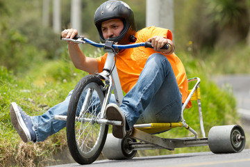Two men wearing helmets are drifting on a trike bike during a normal rally race in the sports event. © Ammit